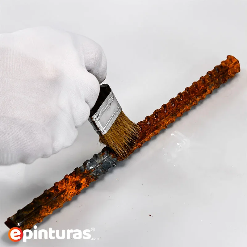 Aplicación directa de un convertidor de óxido mediante brocha sobre una superficie metálica oxidada. El producto reacciona químicamente con la corrosión para estabilizarla y facilitar el posterior pintado.